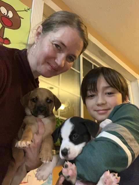 Aimee with her son and foster puppies