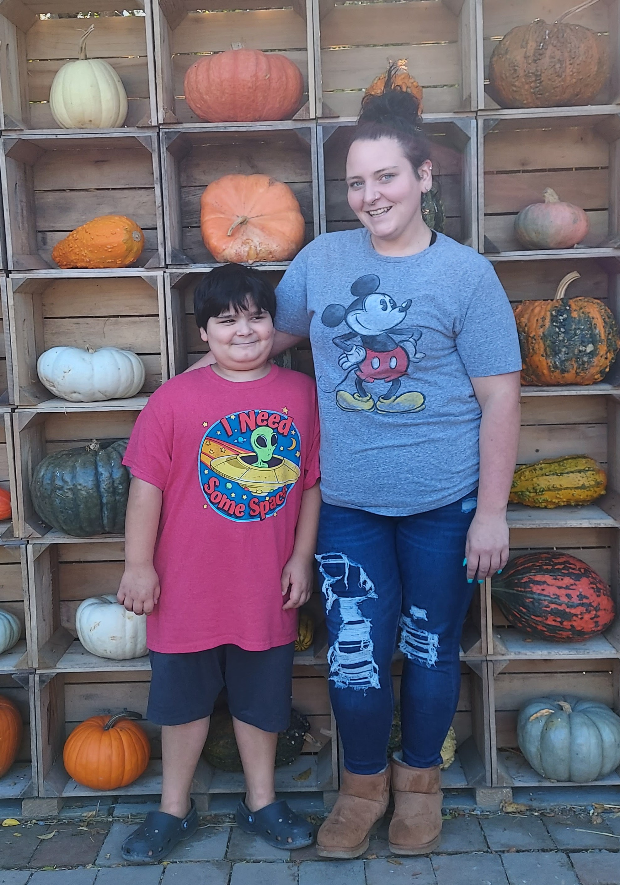 Shannon with son Jax standing in front of pumpkins