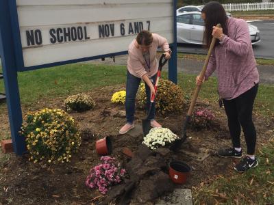 Teachers work to beautify the area around our sign